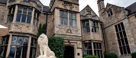 Un bâtiment historique doté d’une entrée imposante, de grandes fenêtres et d’une façade en pierre.