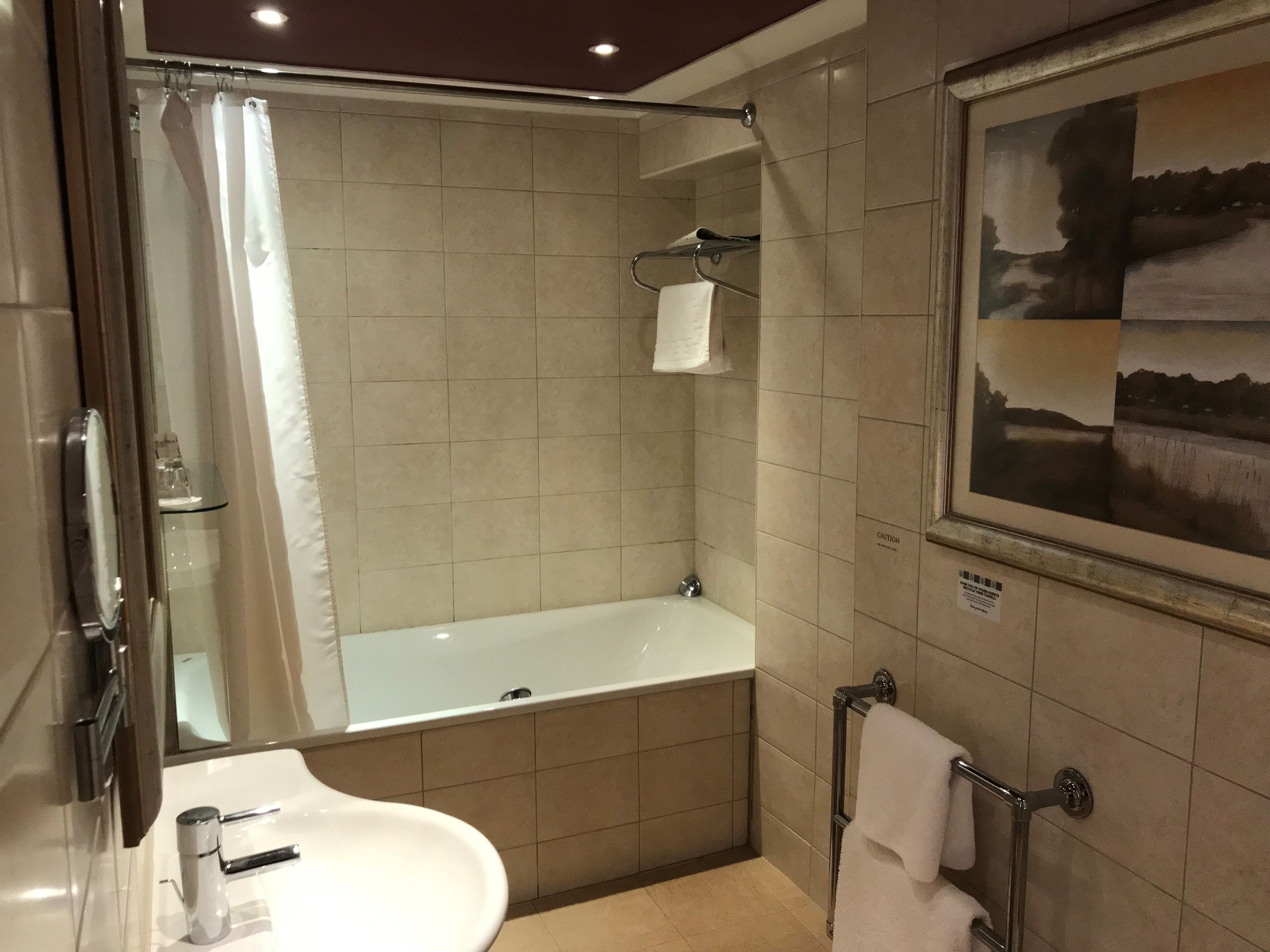 A modern bathroom with a bathtub, a sink, and a glass shower enclosure.
