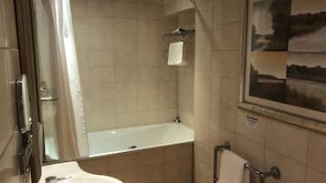 A modern bathroom with a bathtub, a sink, and a glass shower enclosure.