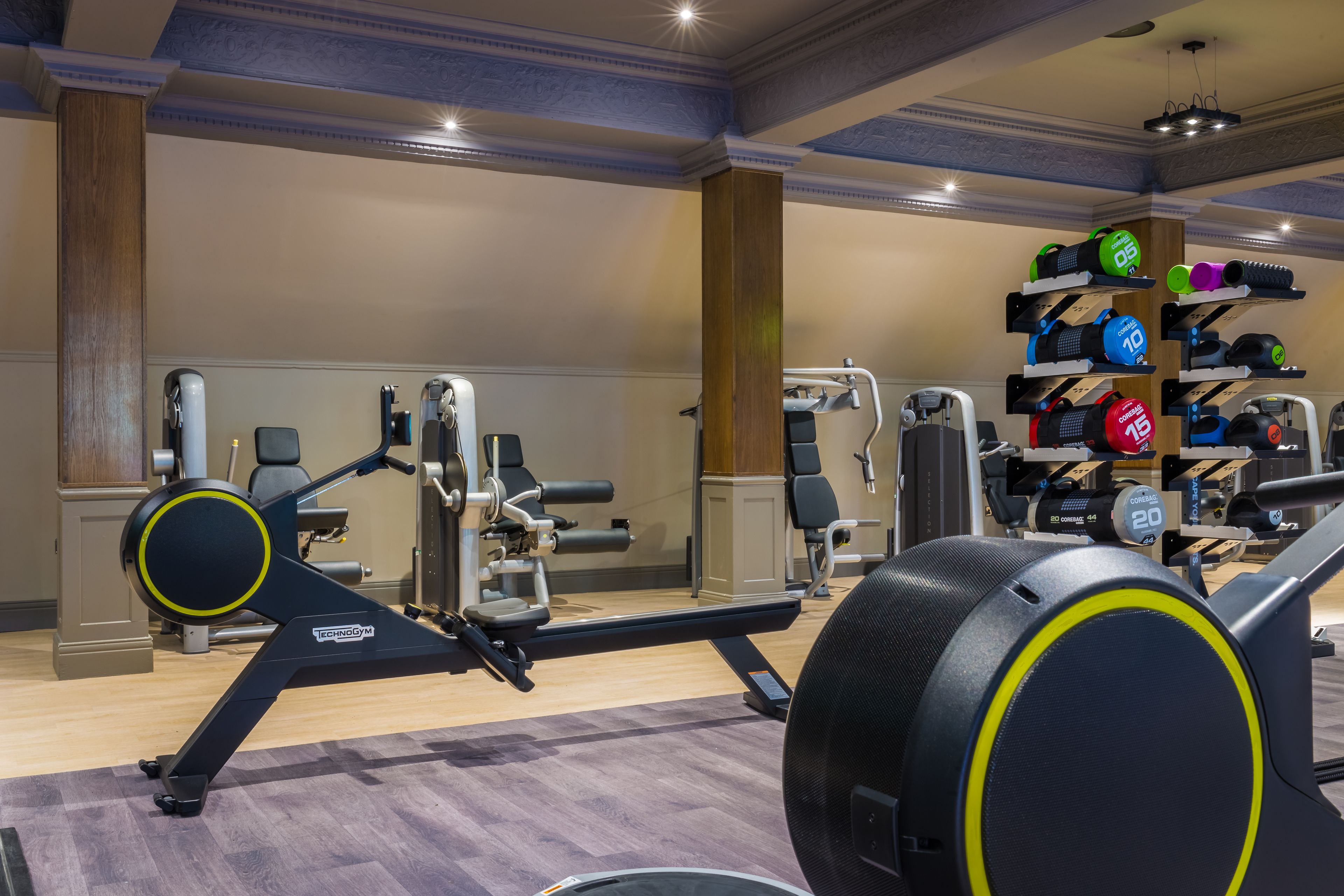 A gym with cardio equipment, weightlifting stations, and a variety of dumbbells.