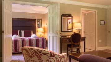 A hotel room with a bed, a desk, a chair, and a table.