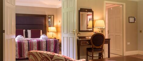 A hotel room with a bed, a desk, a chair, and a table.