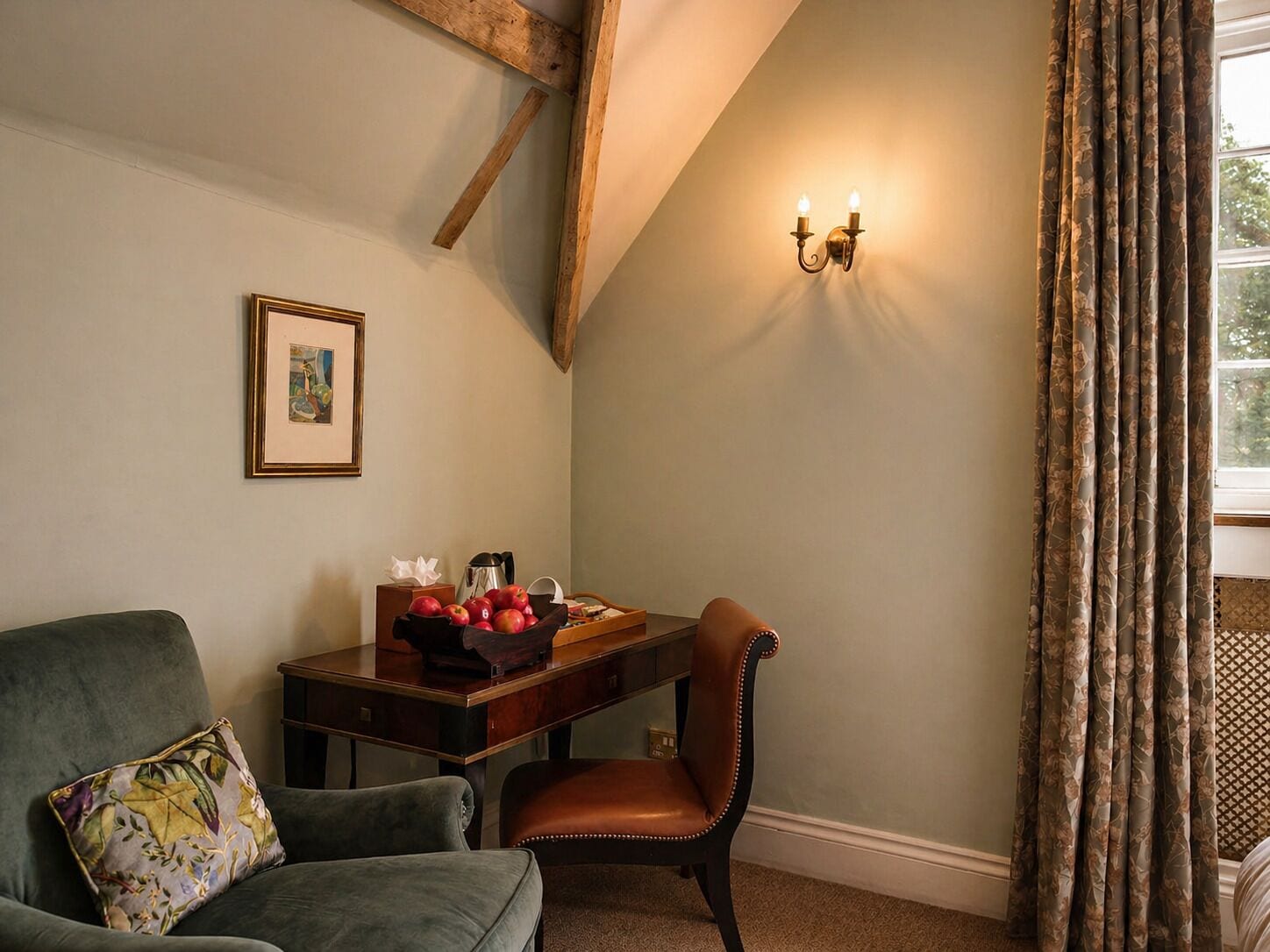 A room with a wooden ceiling, a desk with a fruit bowl, a leather chair, a cushioned armchair, a framed picture, and a window with curtains.