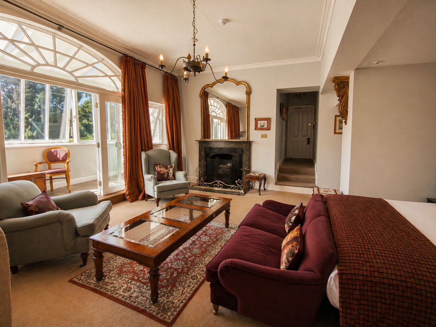 Una sala de estar con chimenea, un sofá, un sillón y una mesa de centro.