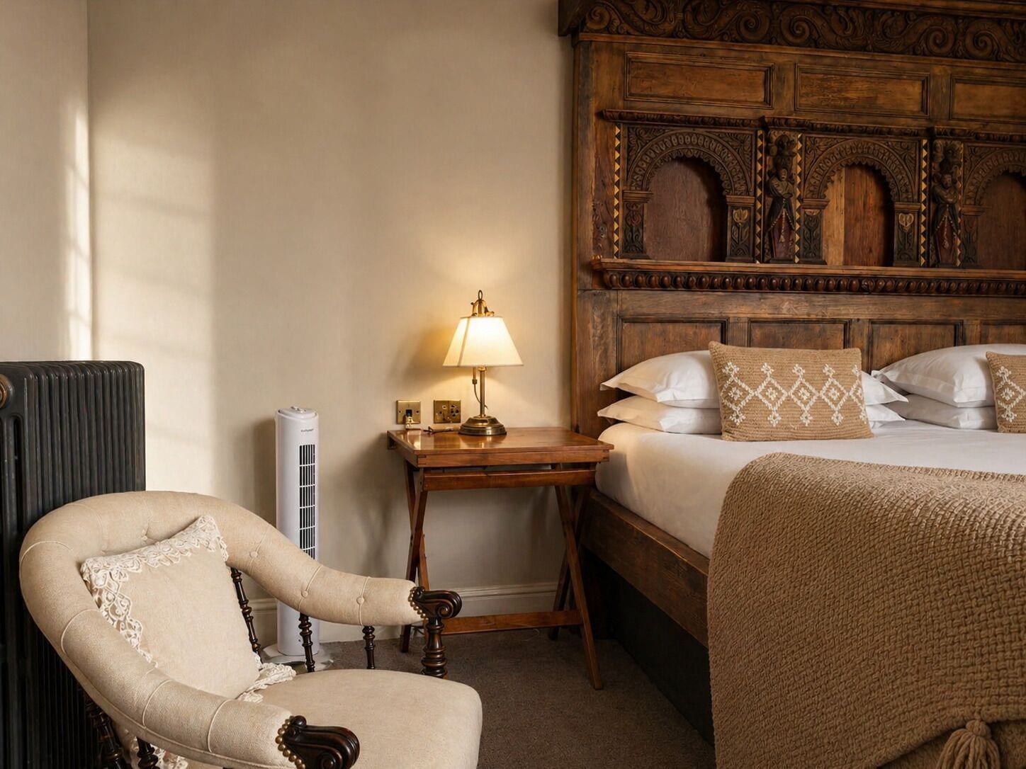 Une chambre d’hôtel avec un lit, une tête de lit en bois, une table de chevet avec une lampe, une chaise et un radiateur.