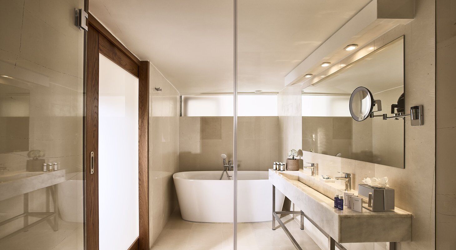 A modern bathroom with a freestanding bathtub, a large mirror, and a vanity with a countertop.