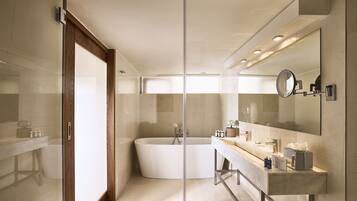 A modern bathroom with a freestanding bathtub, a large mirror, and a vanity with a countertop.
