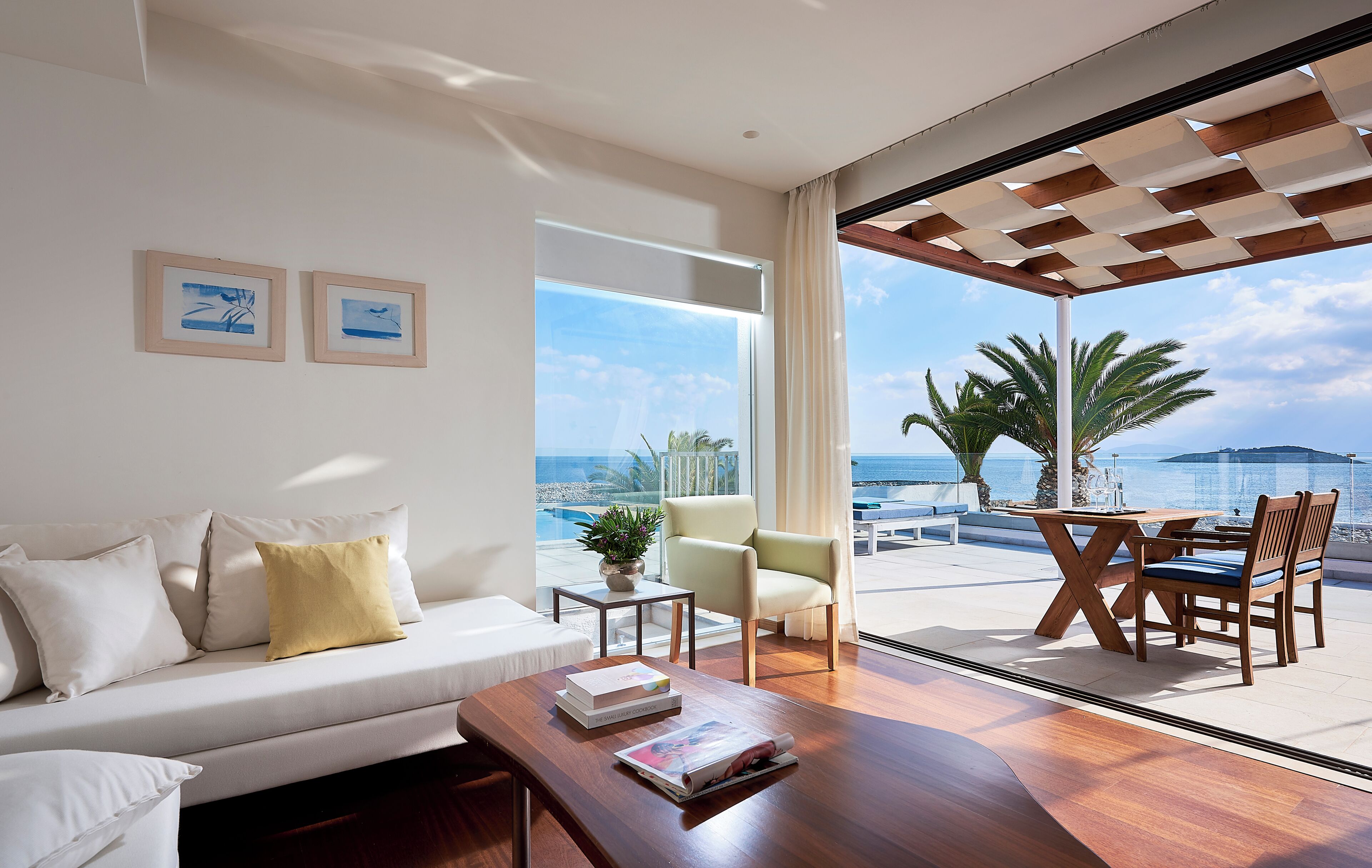 A modern living room with a sofa, coffee table, and a view of the ocean.