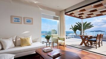 A modern living room with a sofa, coffee table, and a view of the ocean.