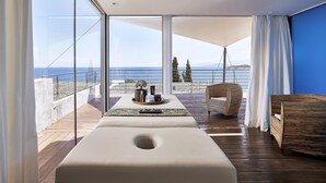 Una habitación moderna con un amplio ventanal, una terraza de madera y vistas al mar.
