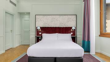 Ein ordentlich eingerichtetes Schlafzimmer mit einem großen Bett, einem Kopfende mit Marmorstruktur und einem Fenster mit Vorhängen.