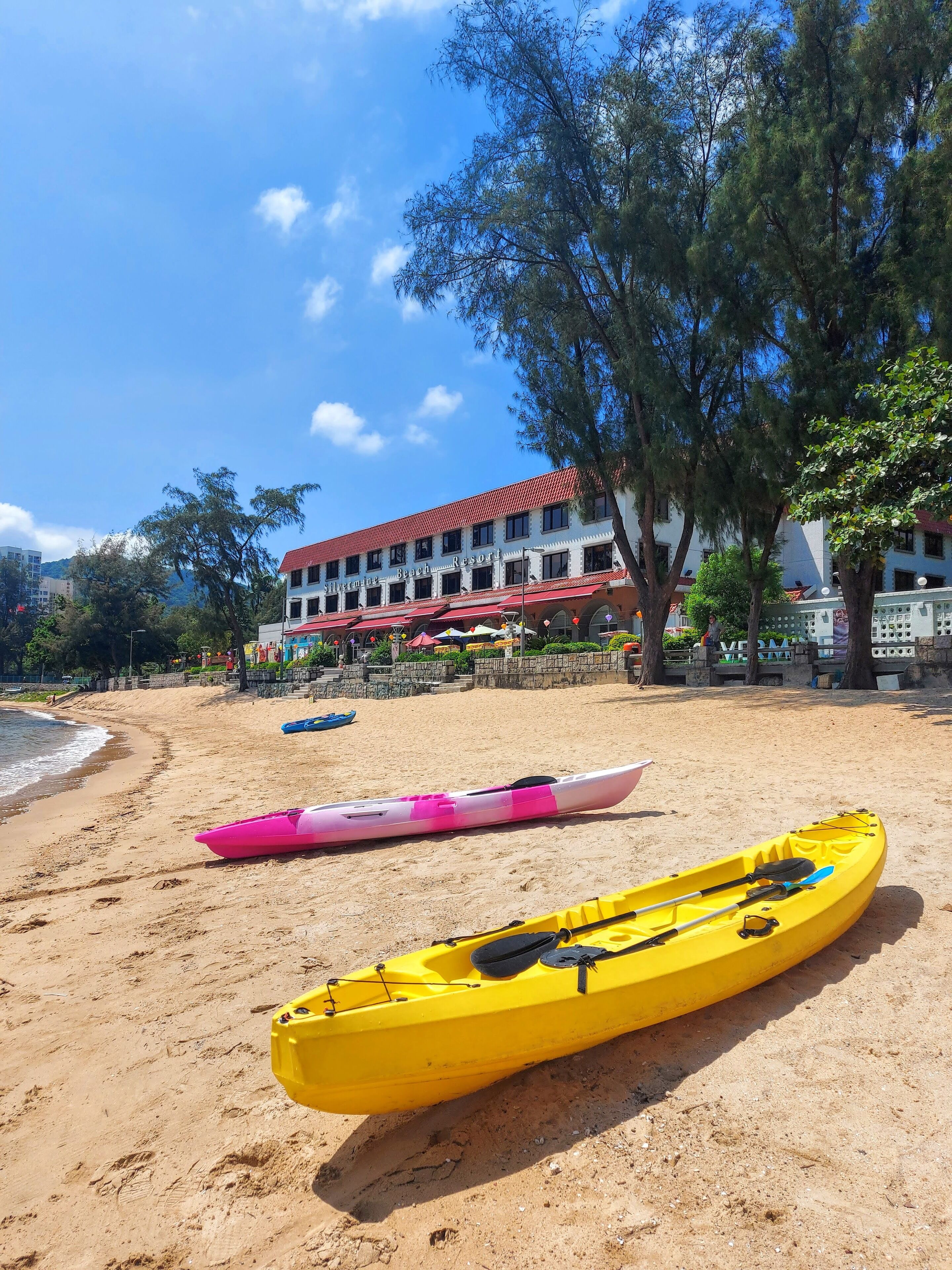 A beach with kayaks and a building labeled "Beach Resort" in the background.