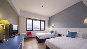 A hotel room with two beds, a desk with a computer, a chair, and a window with a view. - Silvermine Beach Resort (Mui Wo)