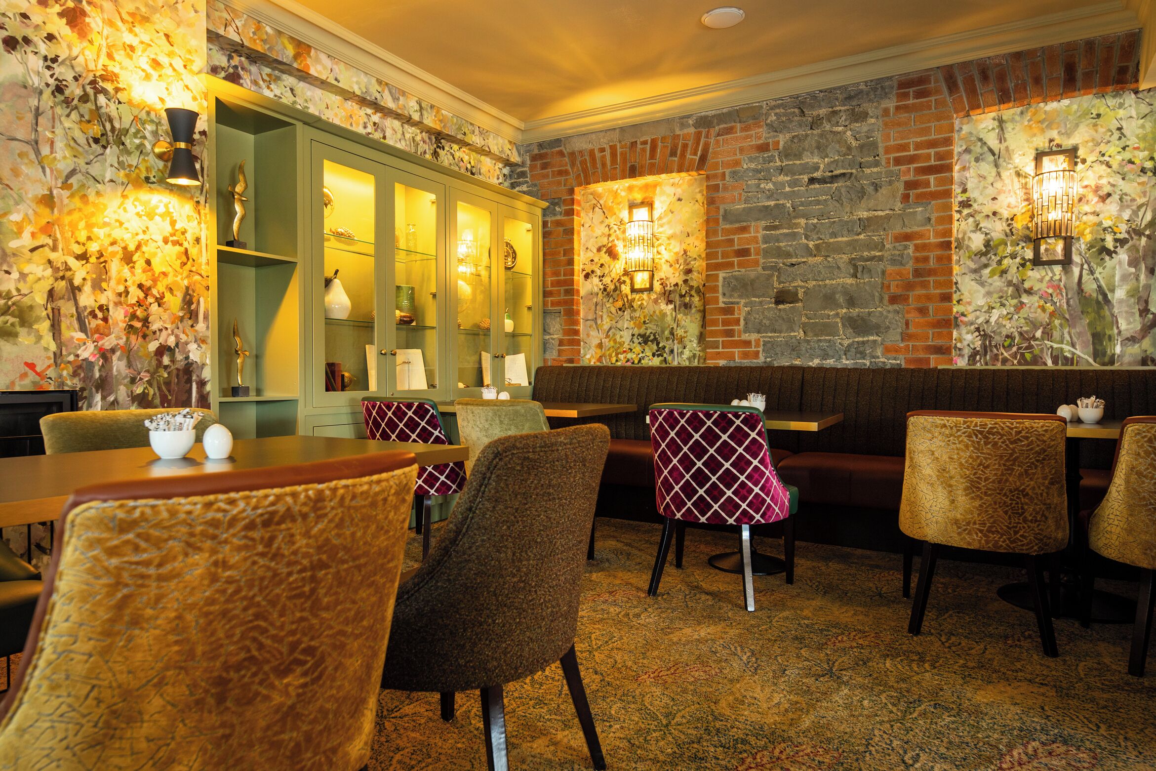 A restaurant interior with booths, tables, and a brick wall.