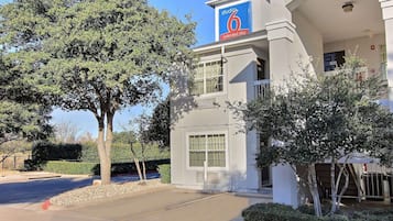 Un hôtel moderne avec une enseigne « Studio 6 Extended Stay », une entrée abritée et un espace de stationnement.