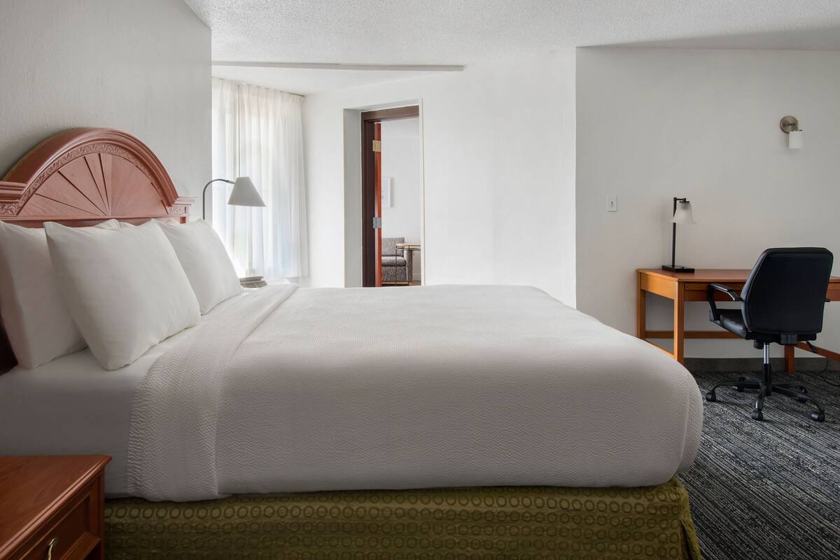 Ein Hotelzimmer mit einem großen Bett, einem Schreibtisch und einem Stuhl.