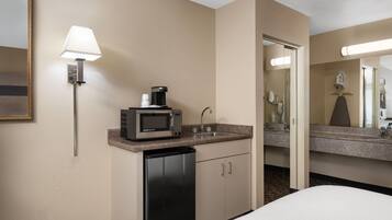 Habitación de hotel con kitchenette, que incluye microondas, cafetera y lavabo.