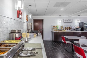 Una cocina moderna con un sistema de bufé, que incluye varios recipientes de comida y una cafetera.