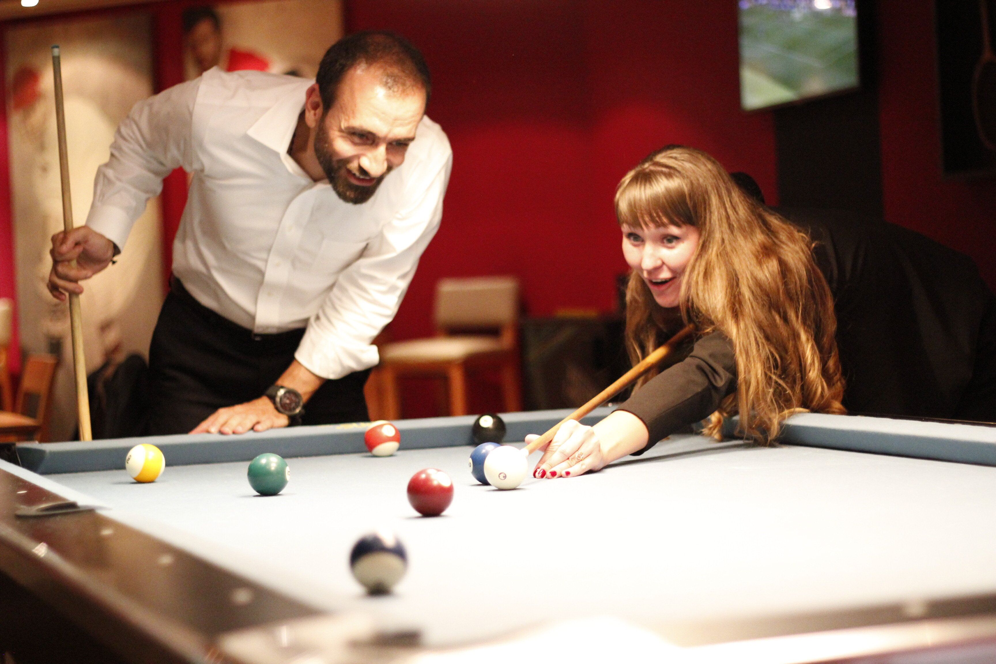 Une table de billard avec des billes et une queue de billard.