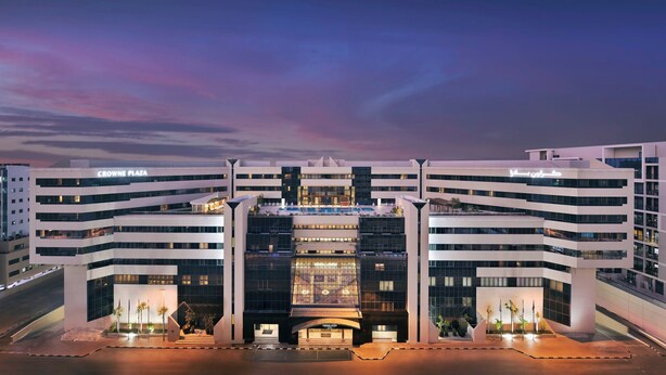 A modern hotel with a prominent entrance, multiple floors, and a clear sky. - Crowne Plaza Dubai Deira by IHG (Dubai)