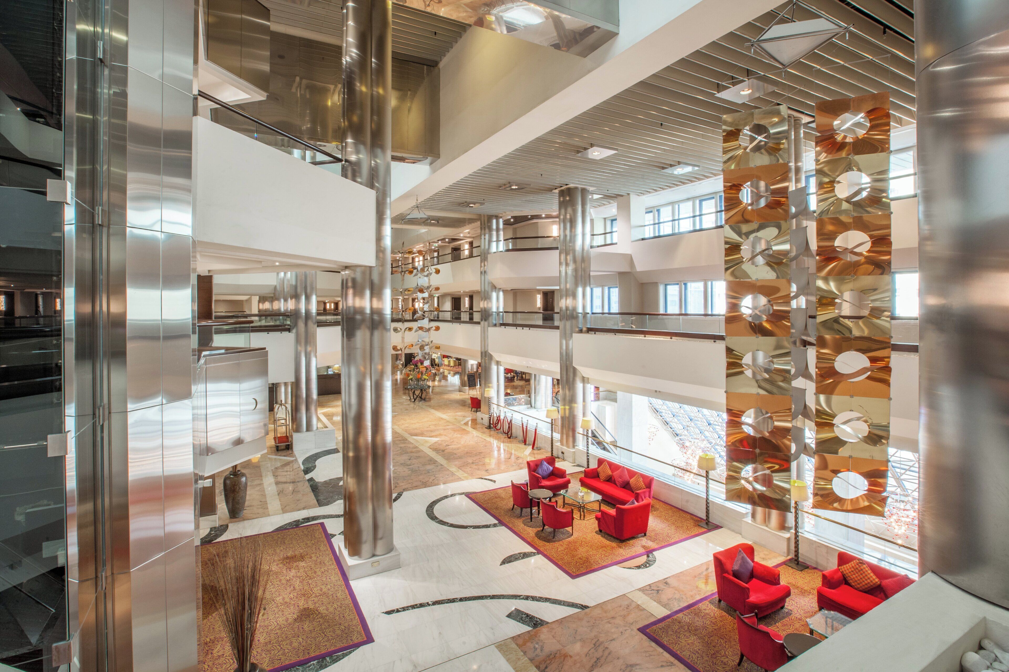 Un atrium à plusieurs niveaux, doté d’un mobilier moderne et d’une colonne centrale.