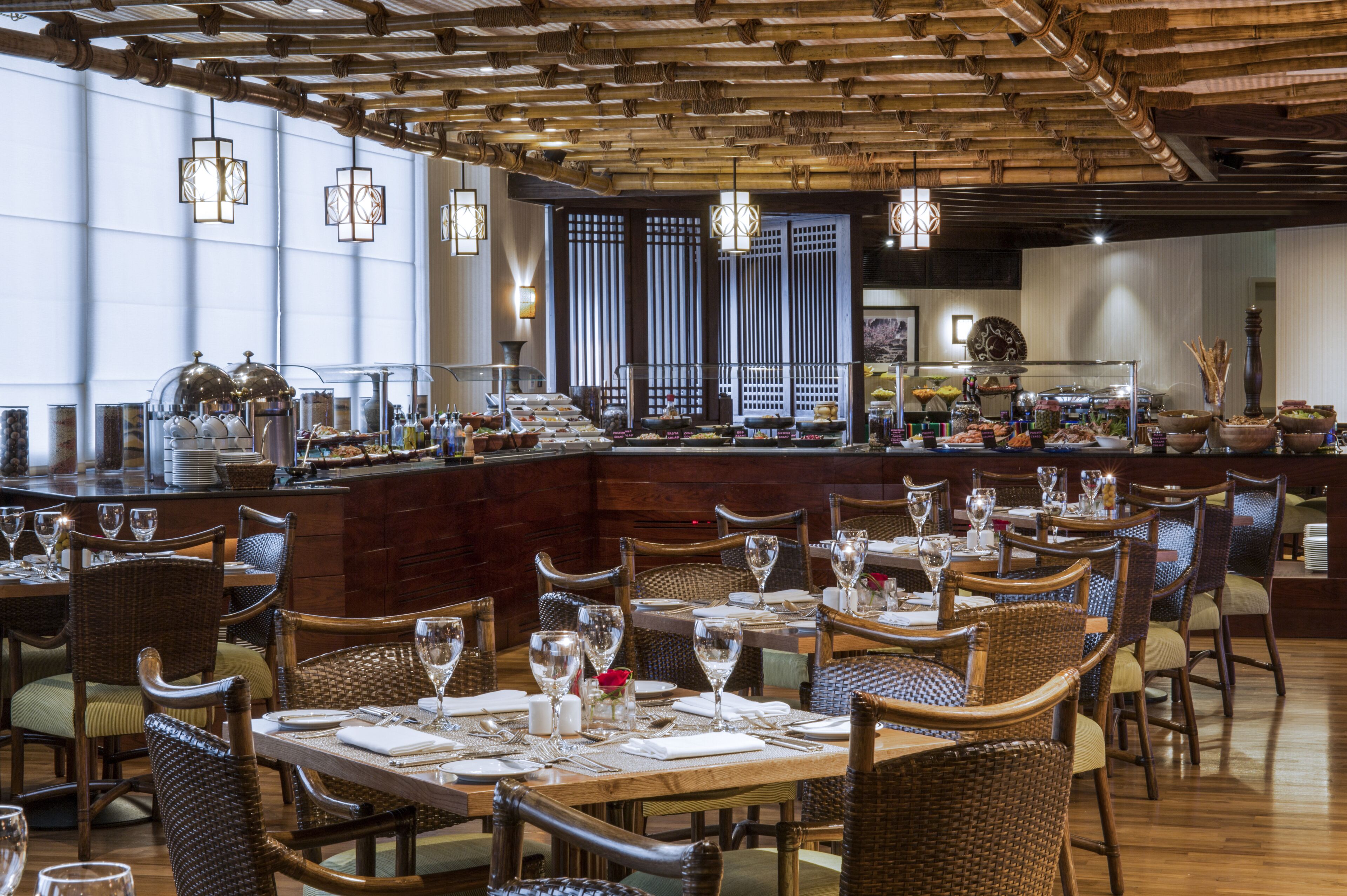 Un restaurant avec des meubles en bois, un coin bar et de grandes fenêtres.