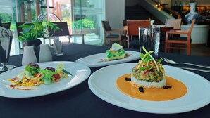 A restaurant setting with a table set for dining, featuring plates of food and a glass of water.