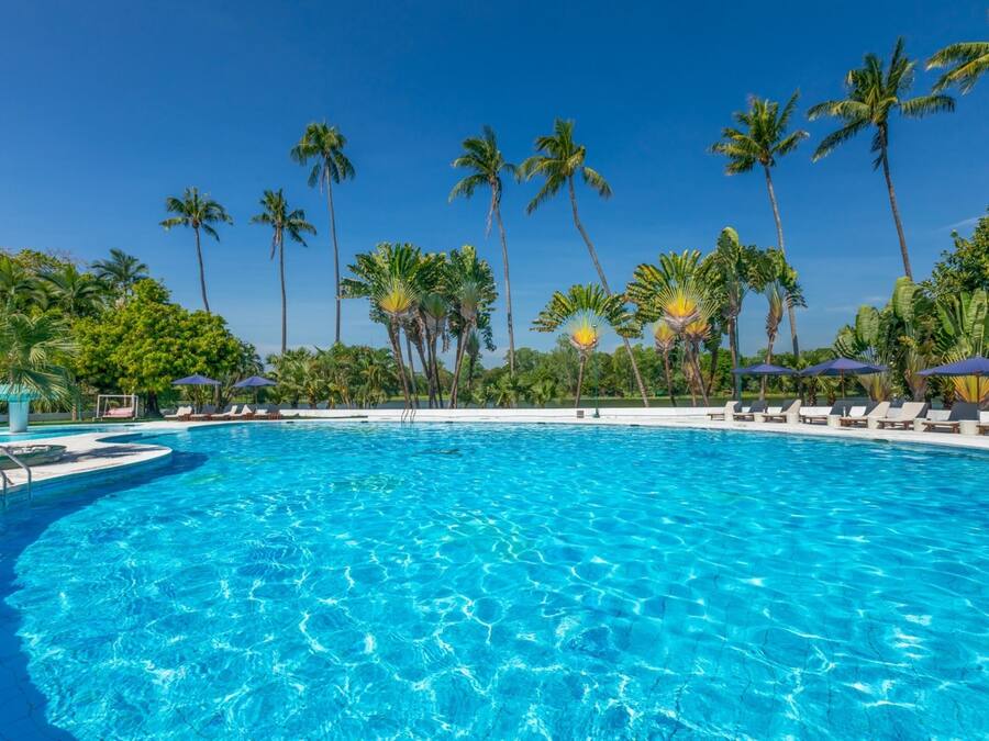 Una piscina al aire libre, camas de piscina gratis, sombrillas