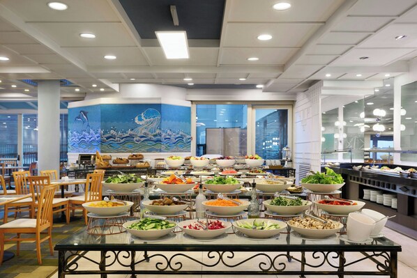 A buffet with various food items and a decorative mural on the wall. - Renaissance Tel Aviv (Tel Aviv)