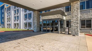 A modern building with a stone facade, large windows, and a covered entrance area. - Comfort Inn Bossier City Casino Area near Shreveport Downtown (Bossier City)