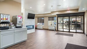 A reception area with a coffee machine, a water dispenser, and a flat-screen TV mounted on the wall. - Comfort Inn Bossier City Casino Area near Shreveport Downtown (Bossier City)