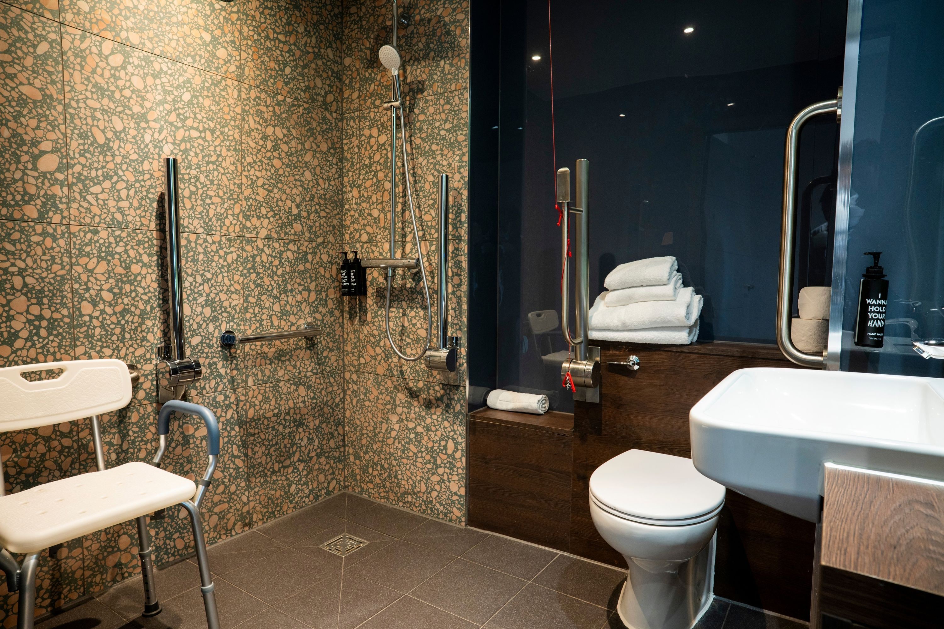 A modern bathroom with a shower, toilet, and sink.