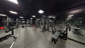 A gym with various exercise equipment, mirrored walls, and a tiled floor. - Village Hotel Coventry (Coventry)