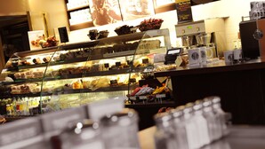 A bakery display case with various baked goods and a coffee machine. - Village Hotel Coventry (Coventry)