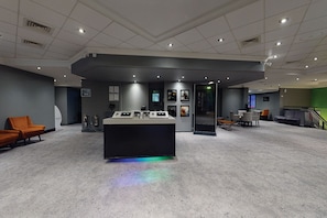 A spacious lobby with a reception desk, seating area, and a staircase leading to an upper level. - Village Hotel Coventry (Coventry)