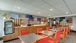 A modern breakfast area with a counter, seating, and a refrigerator displaying food items.