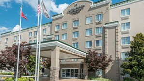 Een Country Inn & Suites gebouw met een beige gevel, meerdere ramen en een overdekte ingang.