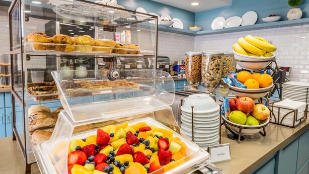 Een buffet met diverse gerechten, waaronder fruit, gebak en een fruitsalade.