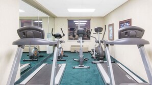 A gym with treadmills, stationary bikes, and an elliptical machine.