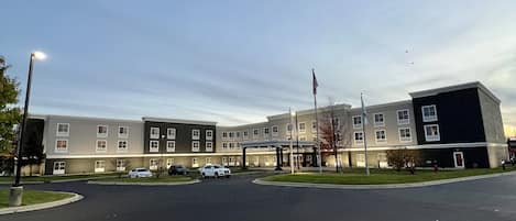 A multi-story building with a parking lot in front.