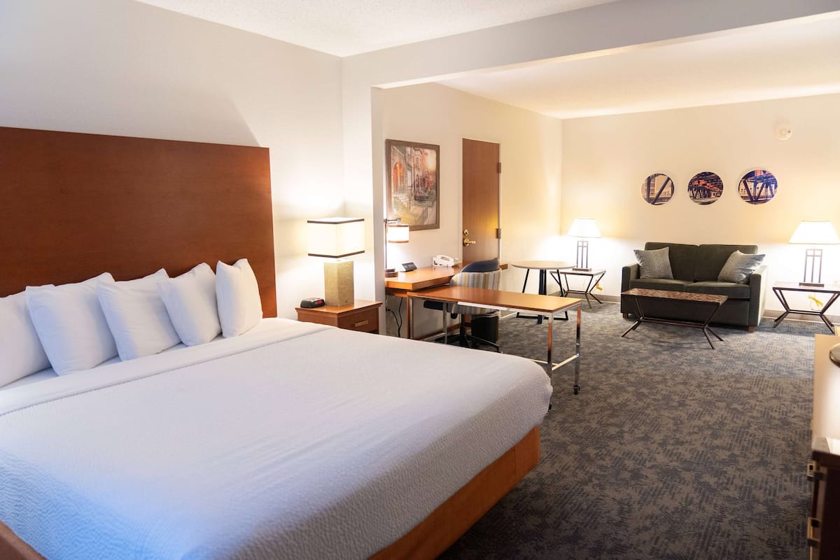 Een hotelkamer met een groot bed, een bureau, een bank en een kleine tafel.