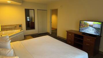 Une chambre d’hôtel équipée d’un lit, d’une télévision, d’une salle de bain et d’une armoire.
