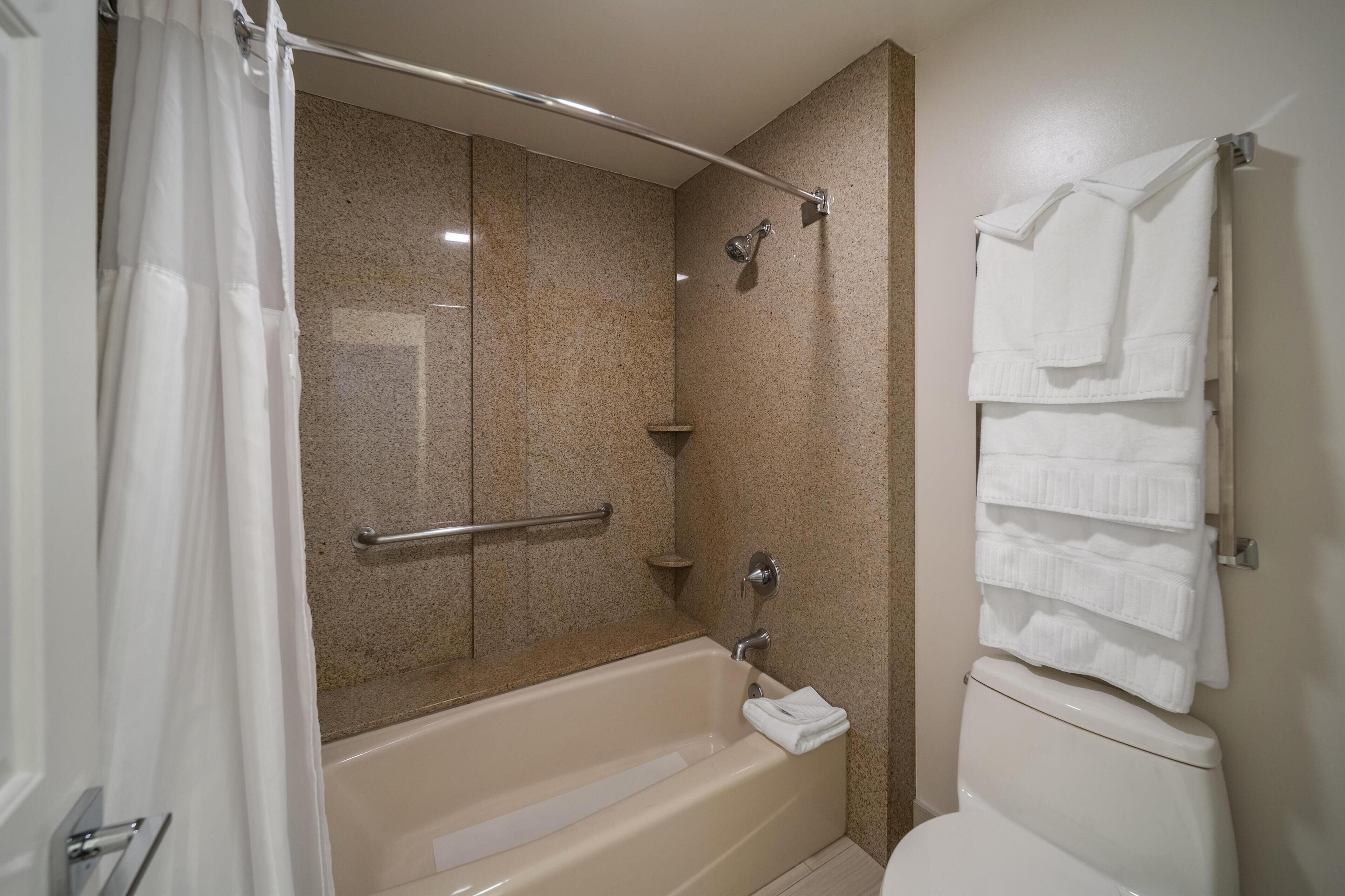 A bathroom with a bathtub, a shower, and a toilet.