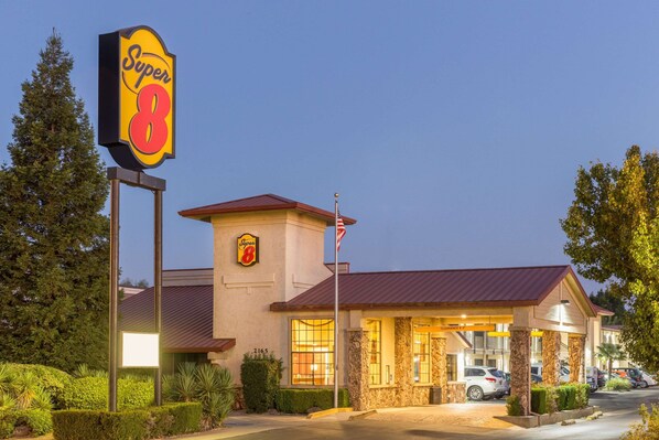 Classic hotel with a prominent red roof and stone facade, offering a welcoming entrance with clear pathway to the main doors.