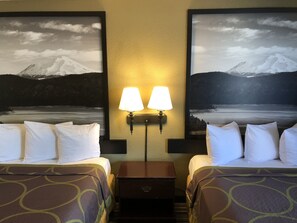 A hotel room with two beds, a nightstand, and two wall-mounted lamps. - Super 8 by Wyndham Corning (Corning)