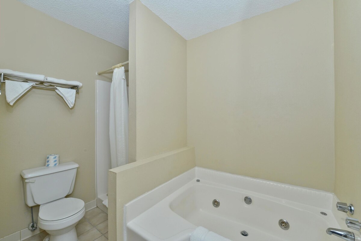 A bathroom with a toilet, a bathtub, and a shower curtain.