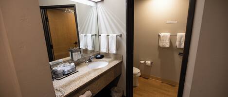 A bathroom with a sink, mirror, and towel rack.