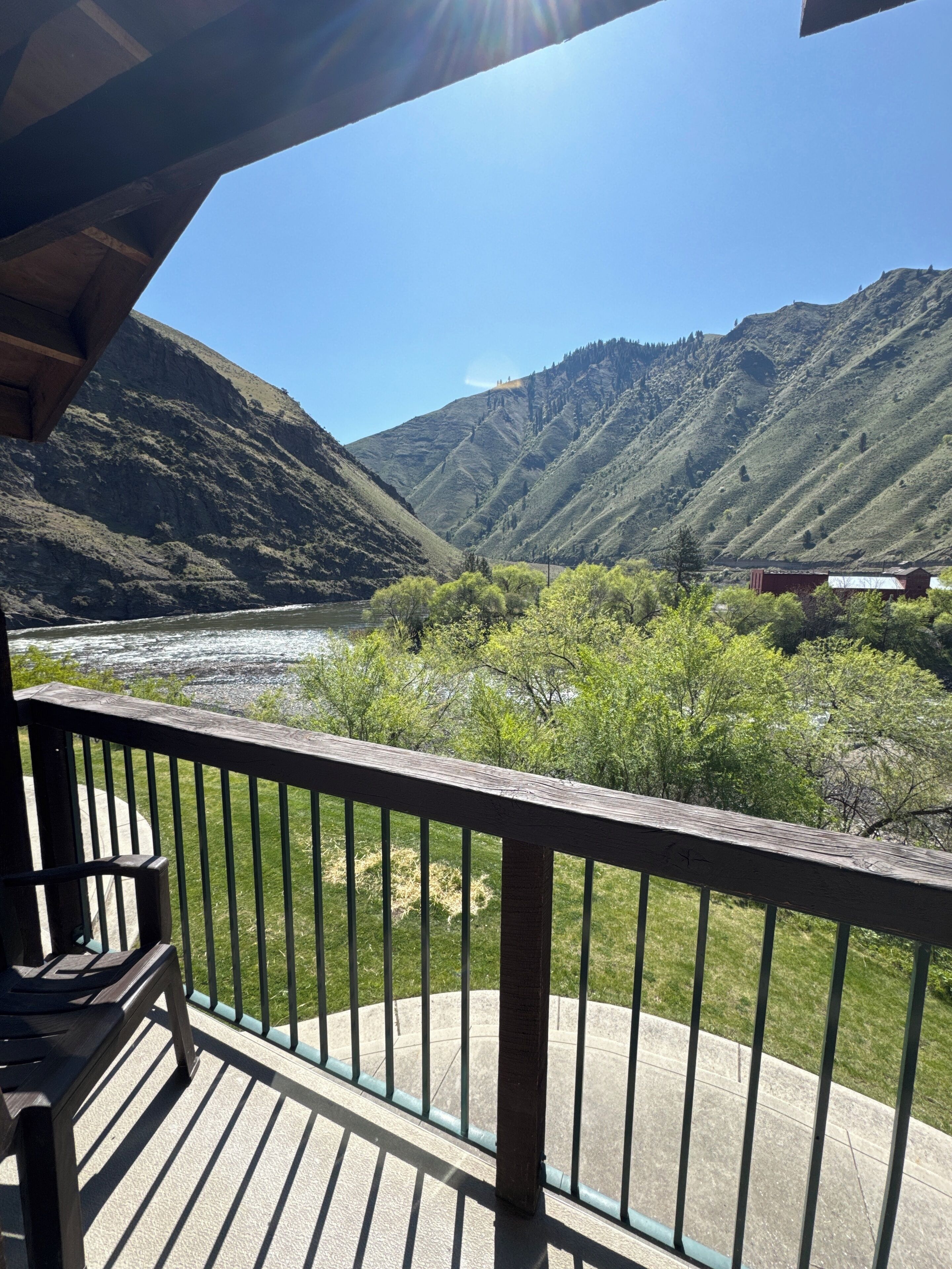 Un balcon avec vue sur une rivière et des montagnes.