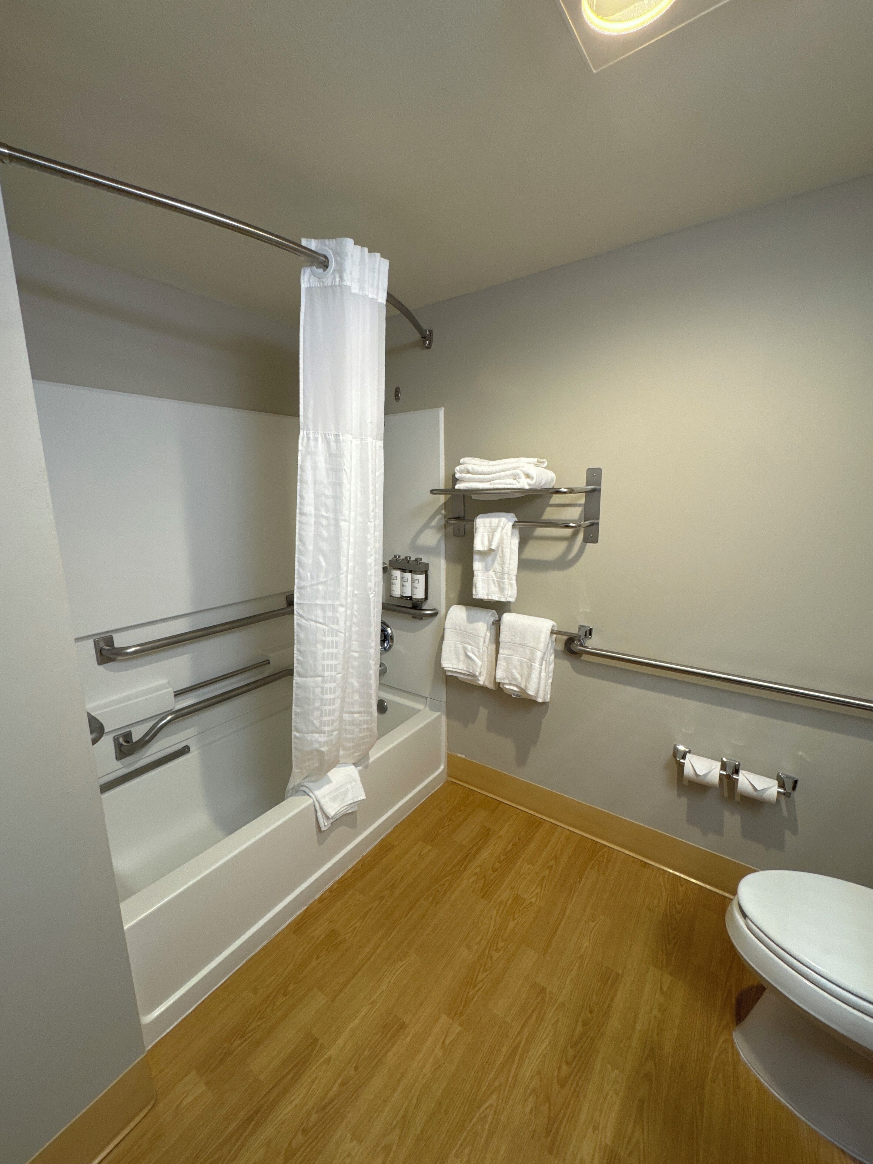 A modern bathroom with a shower, a toilet, and a sink.