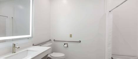 A modern bathroom with a white sink, toilet, and shower area.